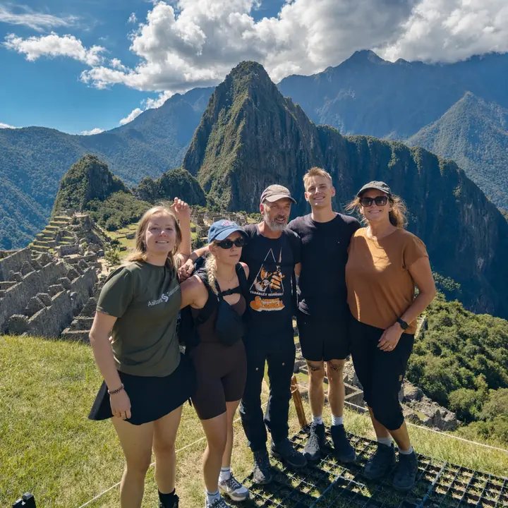 - Five travelers enjoying panoramic views of Machu Picchu