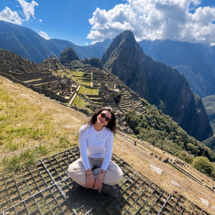 Traveler seated above Machu Picchu on a bright Andean morning