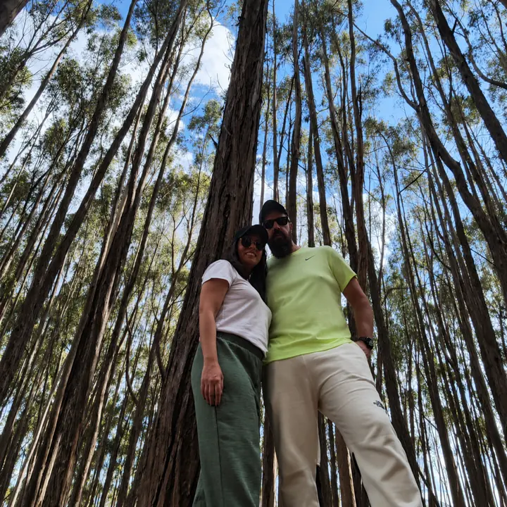 Couple posing among tall eucalyptus trees during a Cusco City Tour.