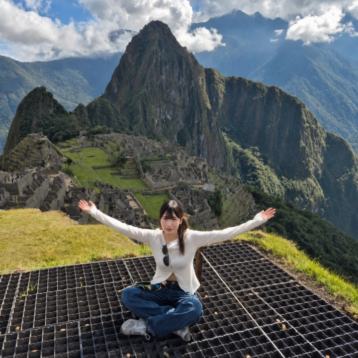 Traveler with open arms before Machu Picchu and Huayna Picchu