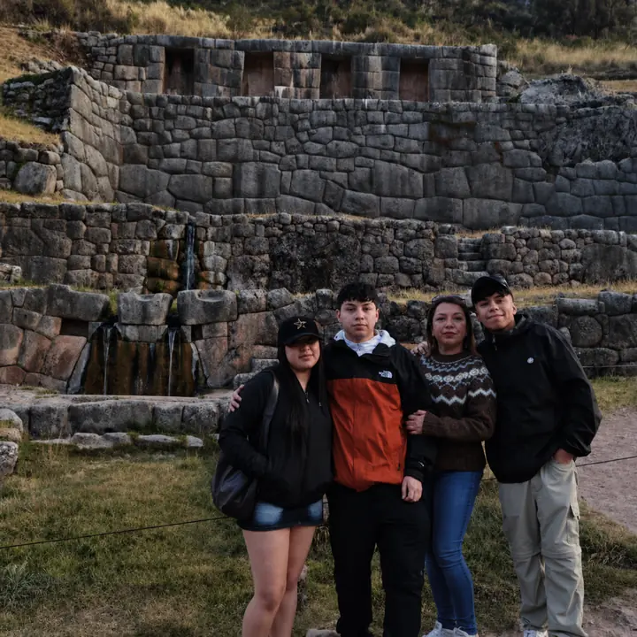 Family group posing at the Tambomachay archaeological site near Cusco.