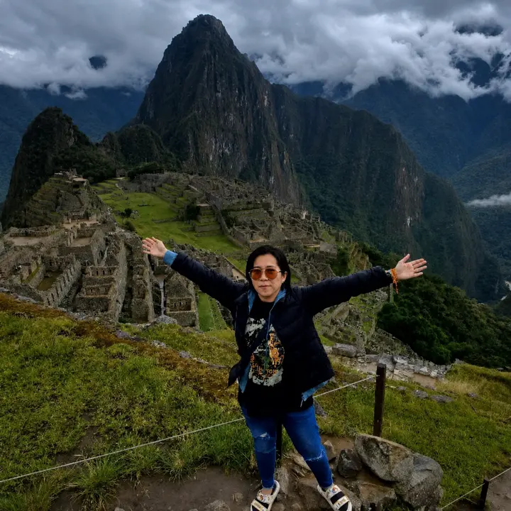 Traveler with open arms overlooking Machu Picchu