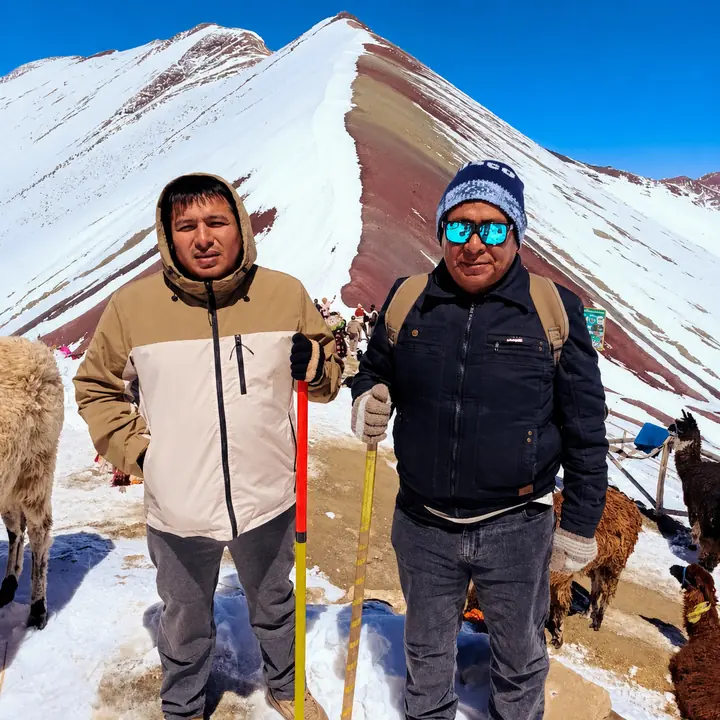 Two hikers at snow-covered Rainbow Mountain near Cusco.