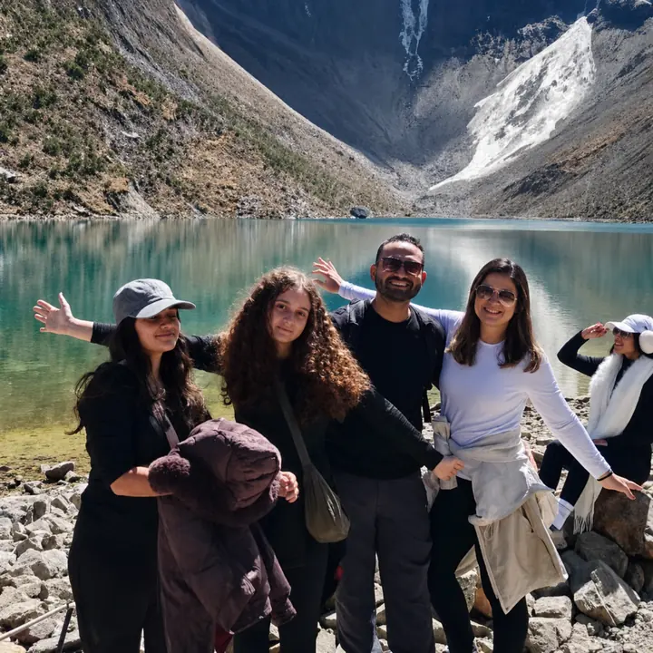 Three hikers celebrating beside Humantay Lake in Peru.