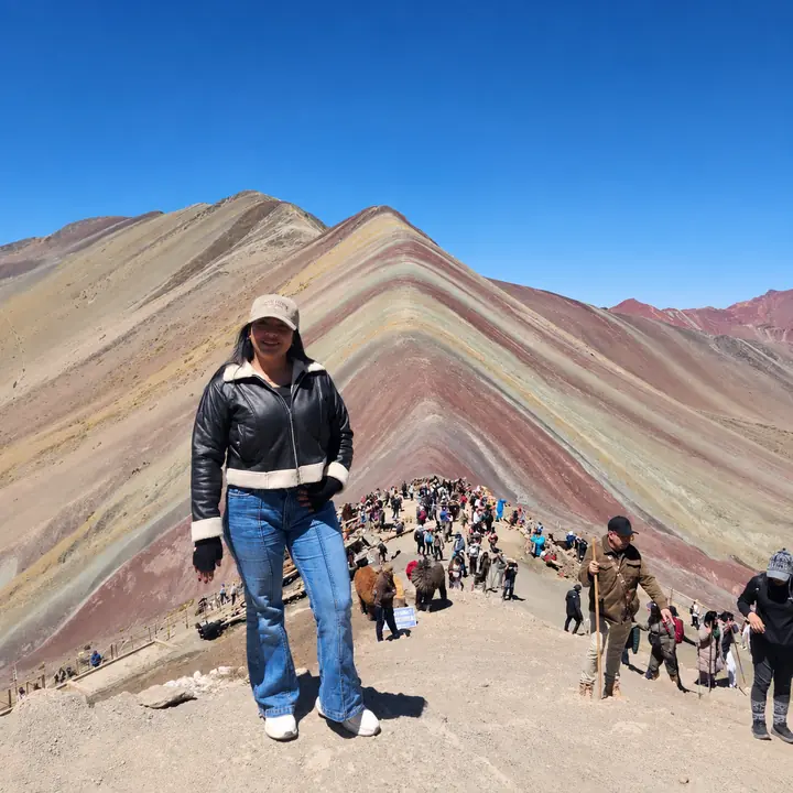 Solo traveler enjoying a panoramic view of Rainbow Mountain.