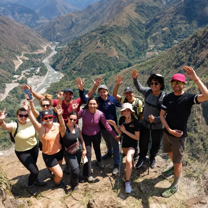 Travel group celebrating at a panoramic viewpoint on the Inca Jungle trek.