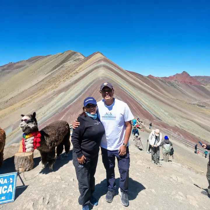 Couple posing with an alpaca at Vinicunca Rainbow Mountain.