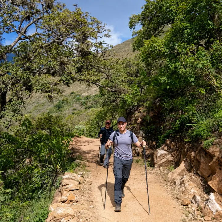 Female hiker using trekking poles on the mountain trail to Choquequirao.