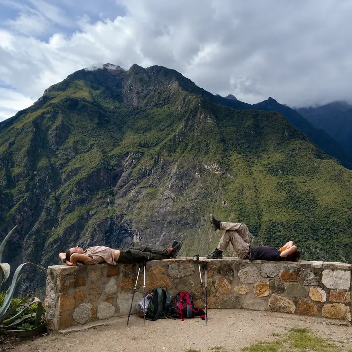 Trekkers taking a break with pack mules beside the Choquequirao mountain trail.